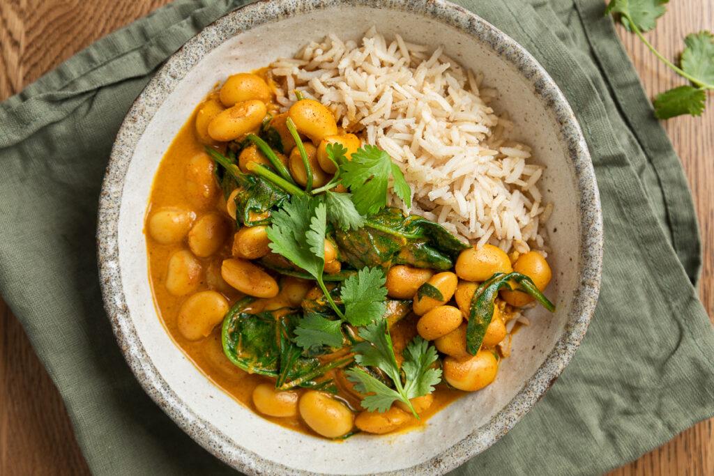A bowl of butter bean curry topped with fresh coriandar.