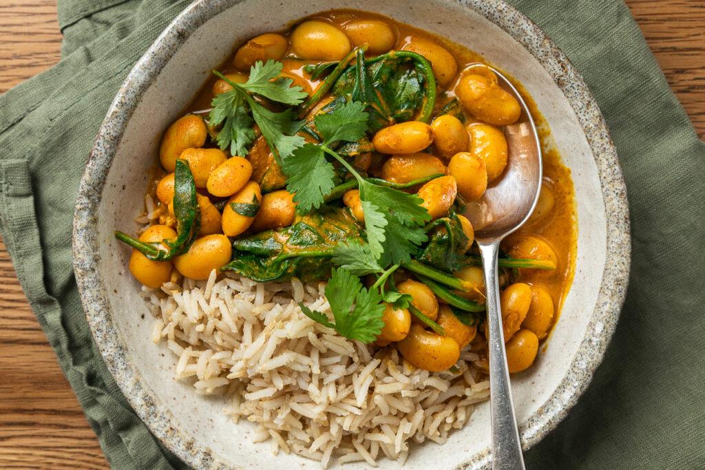 A bowl of butter bean curry served with brown rice.