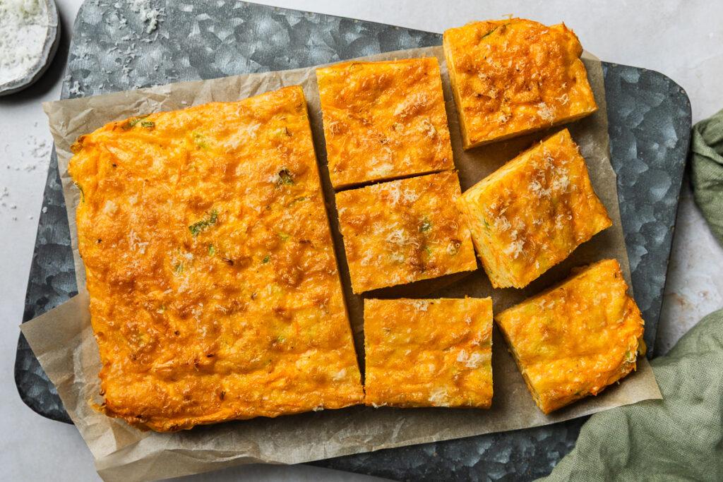 The cooked carrot slice on a metal tin, half cut into squares.