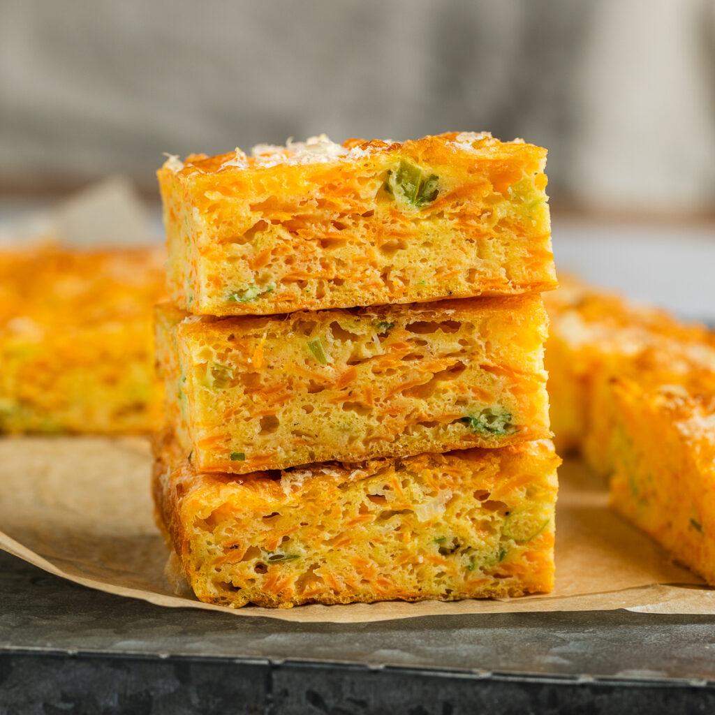 A stack of three squares of carrot slice, with other squares just visible behind.