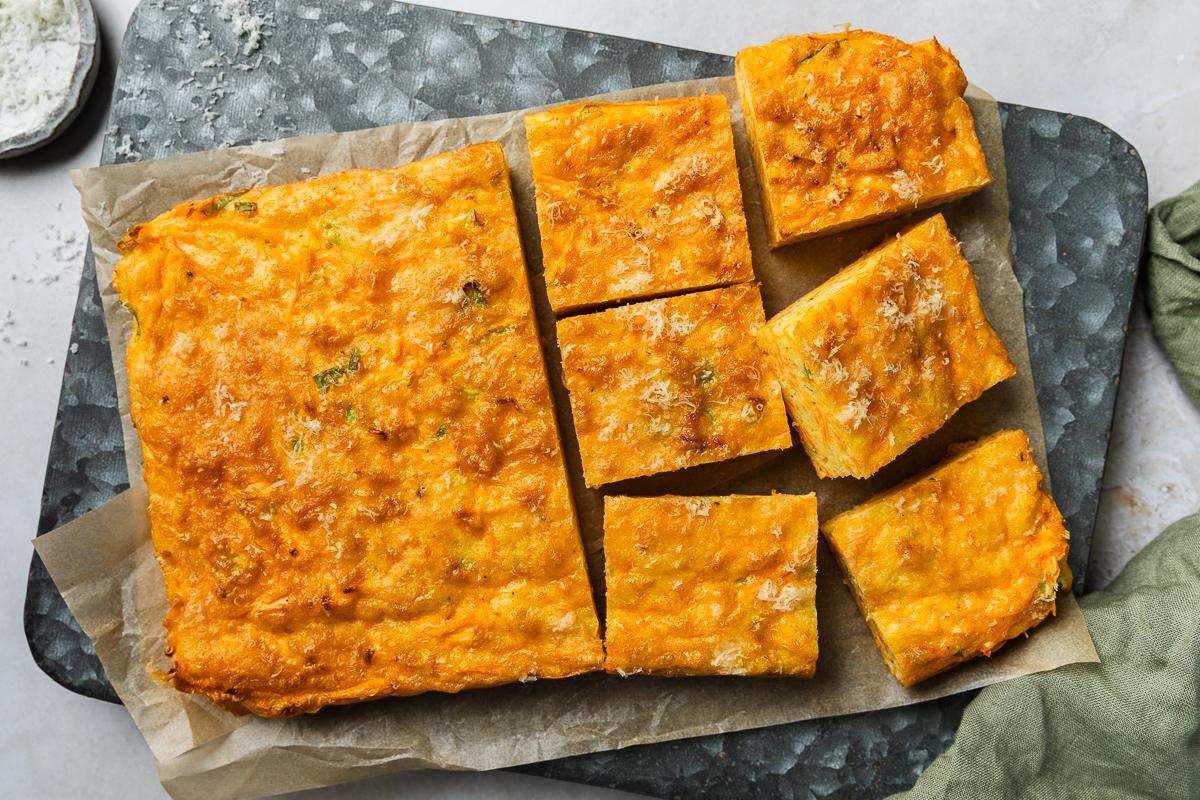 The cooked carrot slice on a metal tin, half cut into squares.