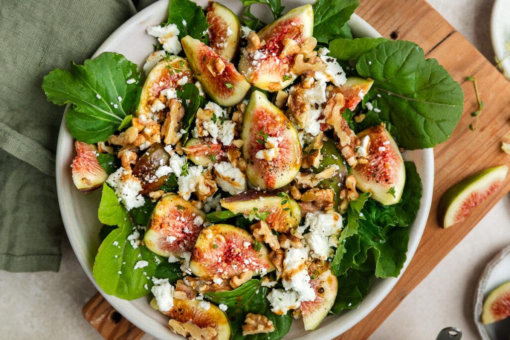 Close up of fig salad with goats cheese and rocket in a bowl.