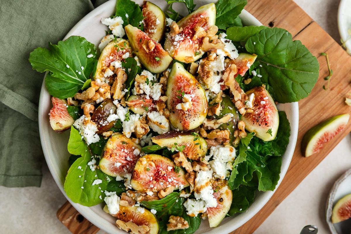 Close up of fig salad with goats cheese and rocket in a bowl.