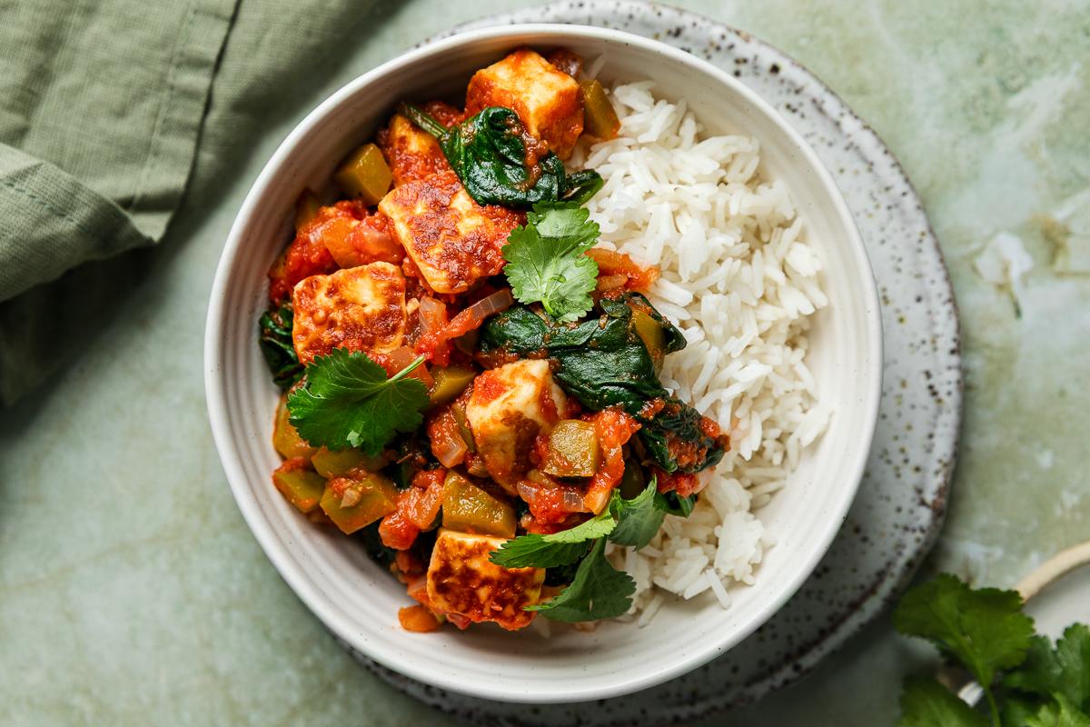 A bowl of halloumi curry served with rice.