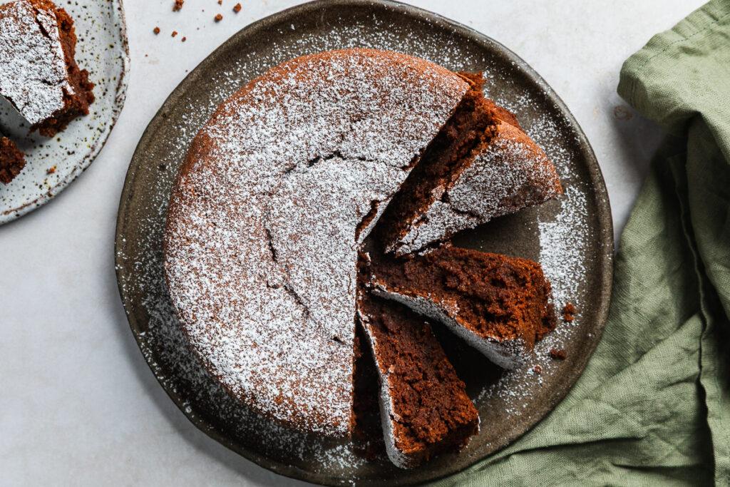 Overhead photo of Italian flourless chocolate cake with three slices on their side to show the texture.