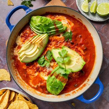 Baked eggs topped with sliced avocado and fresh coriander.