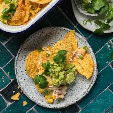 A plate of tuna nachos topped with mashed avocado.