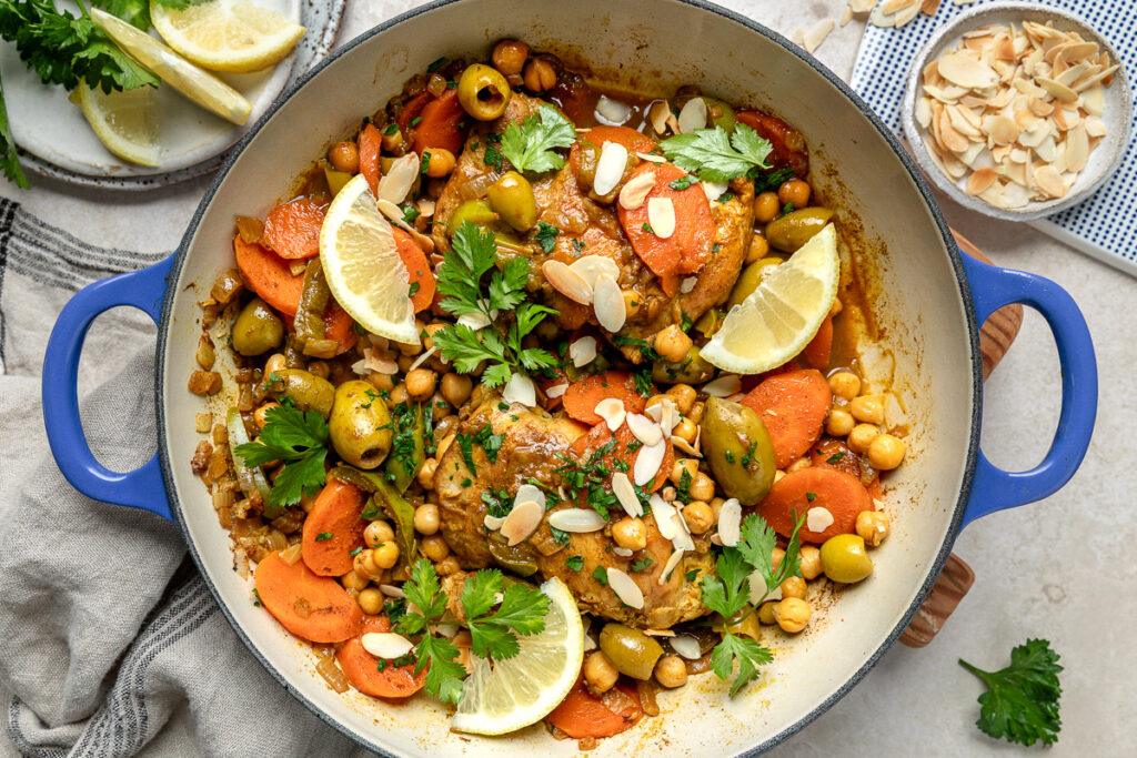 Chicken tagine in a pan sprinkled with flaked almonds.
