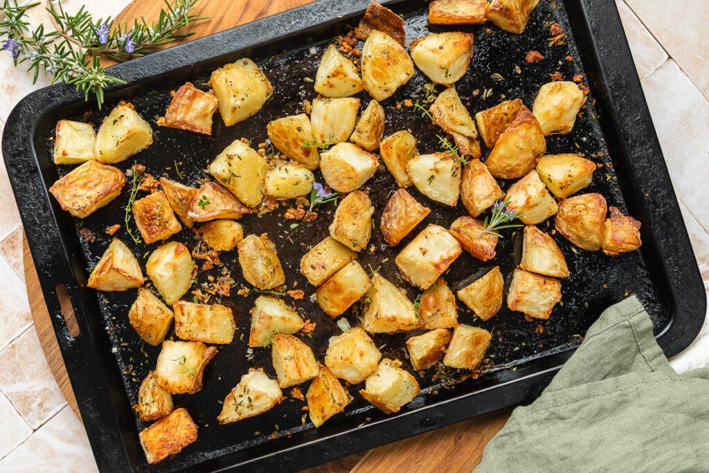 A tray of roasted potatoes with garlic and herbs.