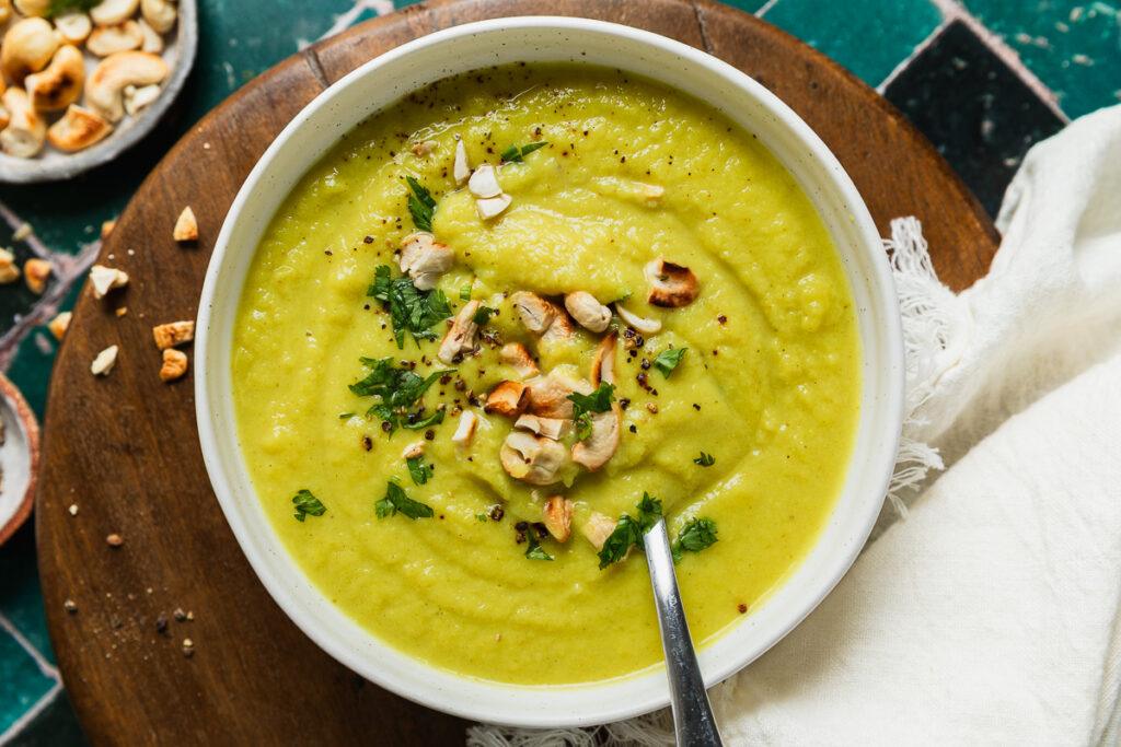 A bowl of thick and comforting cauliflower soup topped with toasted cashews.
