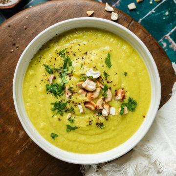 A bowl of spiced cauliflower leek soup topped with cashews.
