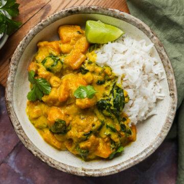 Close up of a bowl of the slow cooker chickpea curry served with rice.