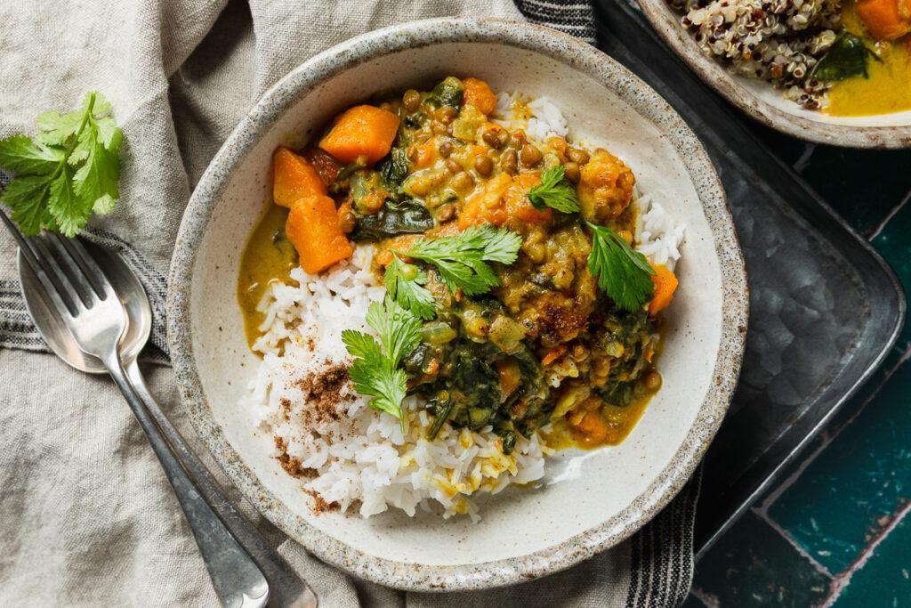 A bowl of sweet potato and brown lentil dahl served with rice.