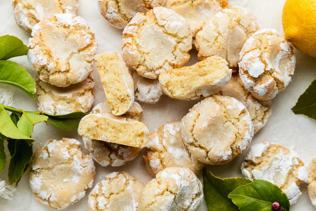 Close up of homemade gluten-free almond cookies with some halved to show their chewy texture.